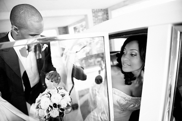 black and white photo - the happy couple getting into car to leave the ceremony -photo by Houston based wedding photographer Adam Nyholt